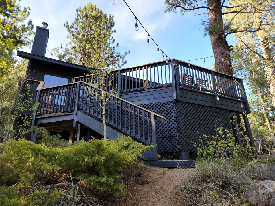 Exterior staircase and railing leading from the riverside grounds to the raised cabin deck.
