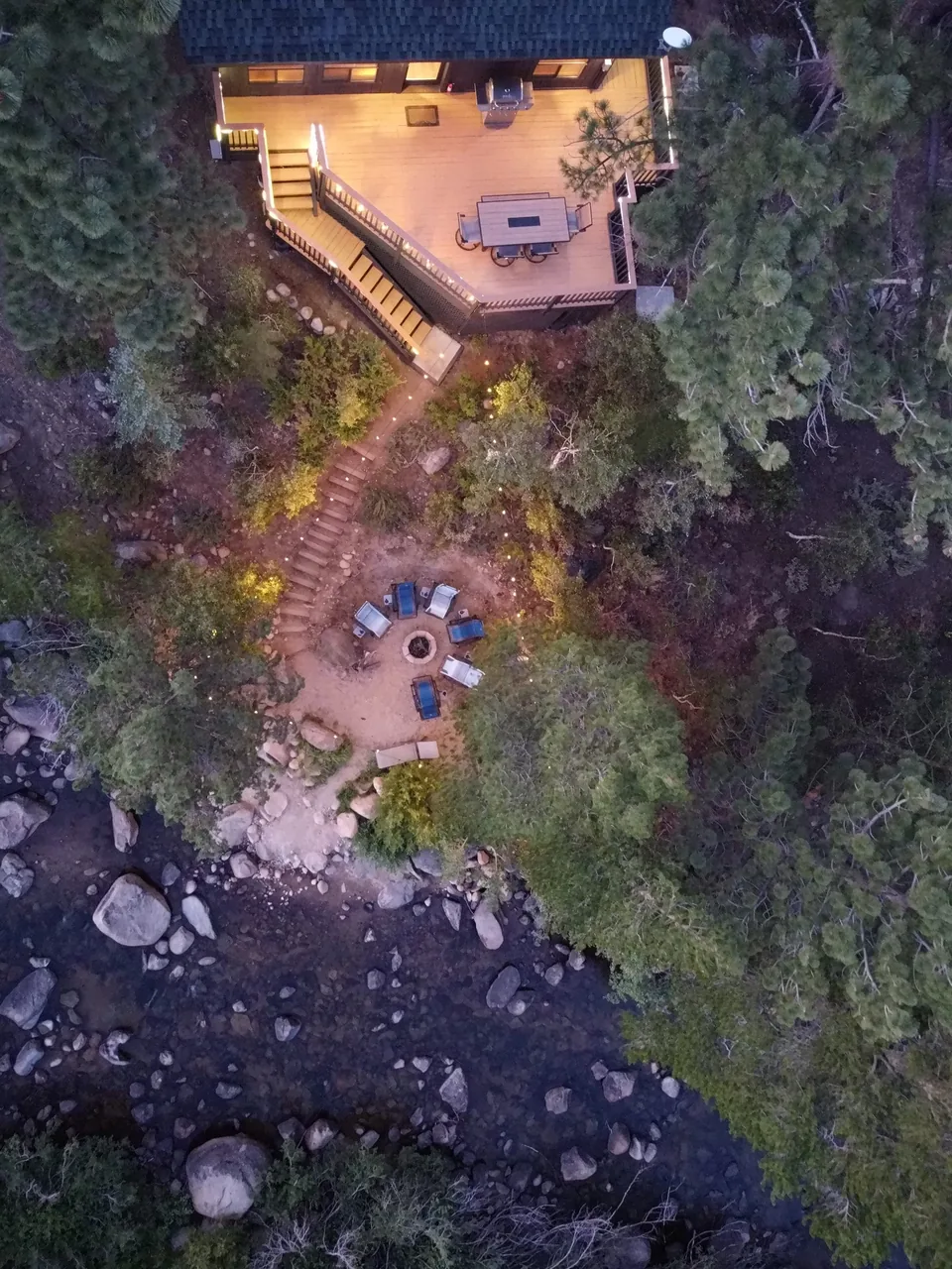Aerial view of the cabin deck, stairs and seating area beside the Carson River in Hope Valley.