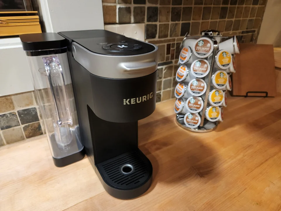 Keurig coffee maker and a rack of coffee pods on the wooden kitchen countertop.