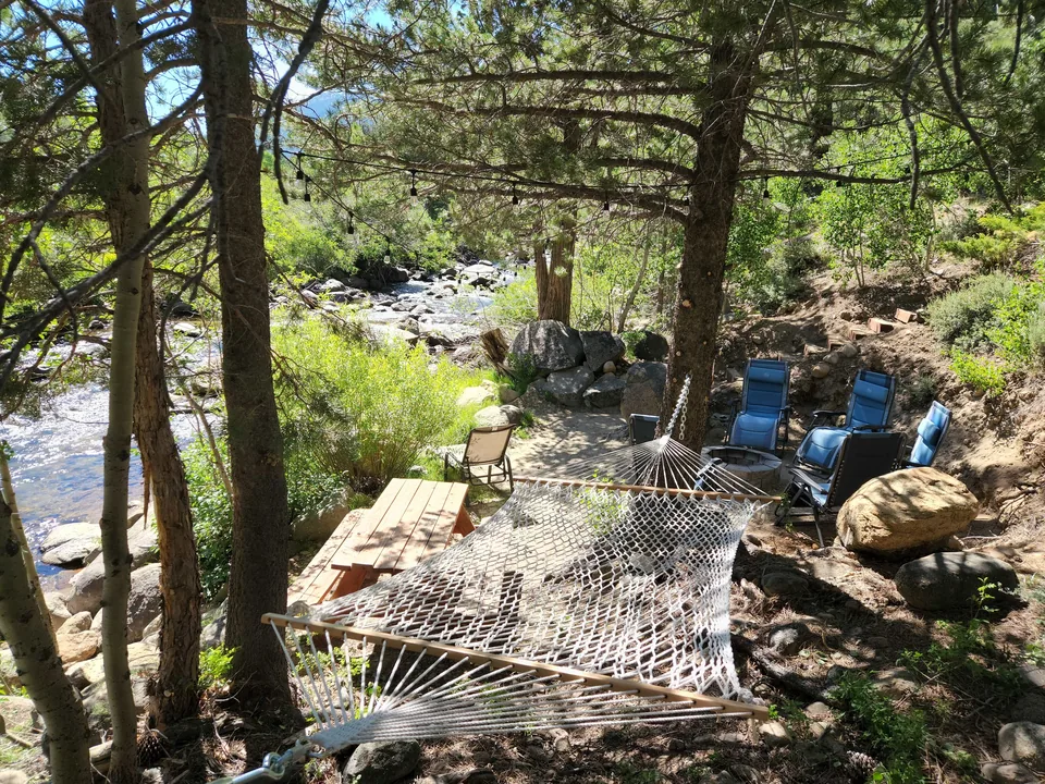 Rope hammock between pine trees beside the Carson River at Tahoe River Cabin.